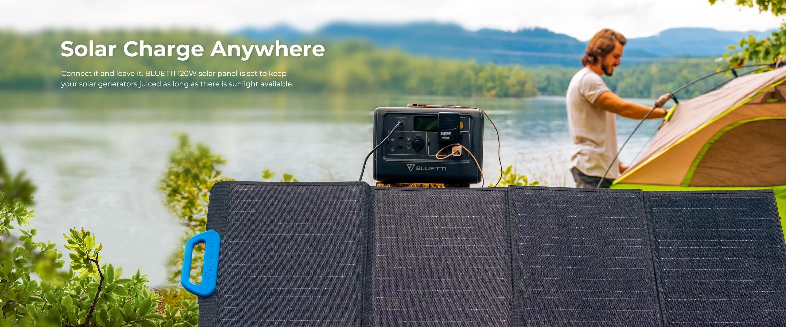 BLUETTI 120W 24V Monocrystalline Portable Solar Panel A Bluetti 120W 24V Monocrystalline Portable Solar Panel and a Bluetti generator sit by a lake with trees and hills, as a man sets up his tent nearby, under the text: Solar Charge Anywhere.