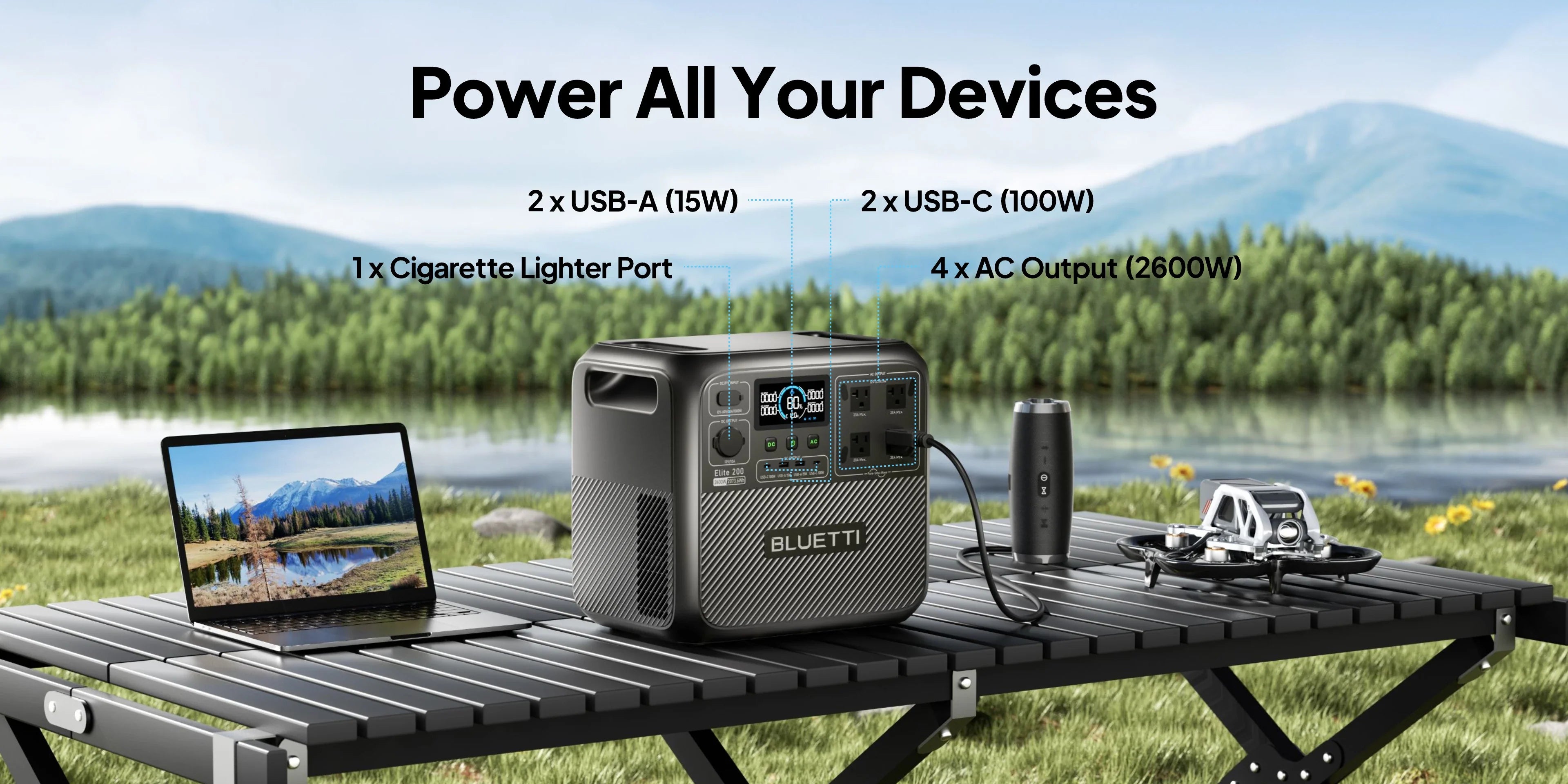 An Eco Solar Kits Bluetti Elite 200 V2 Portable Power Station (2600W, 2073.6Wh) is positioned on a table outdoors by a lake, powering a laptop and several other devices. This versatile solar generator highlights its array of connections, including USB-A, USB-C, a cigarette lighter port, and four AC outputs.