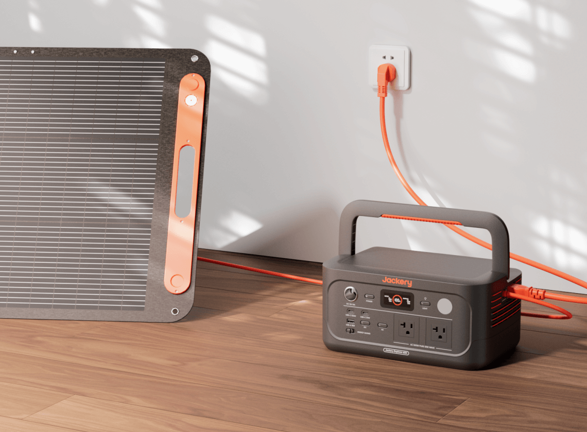 Jackery Explorer 600 v2 charging from a wall outlet beside a SolarSaga panel